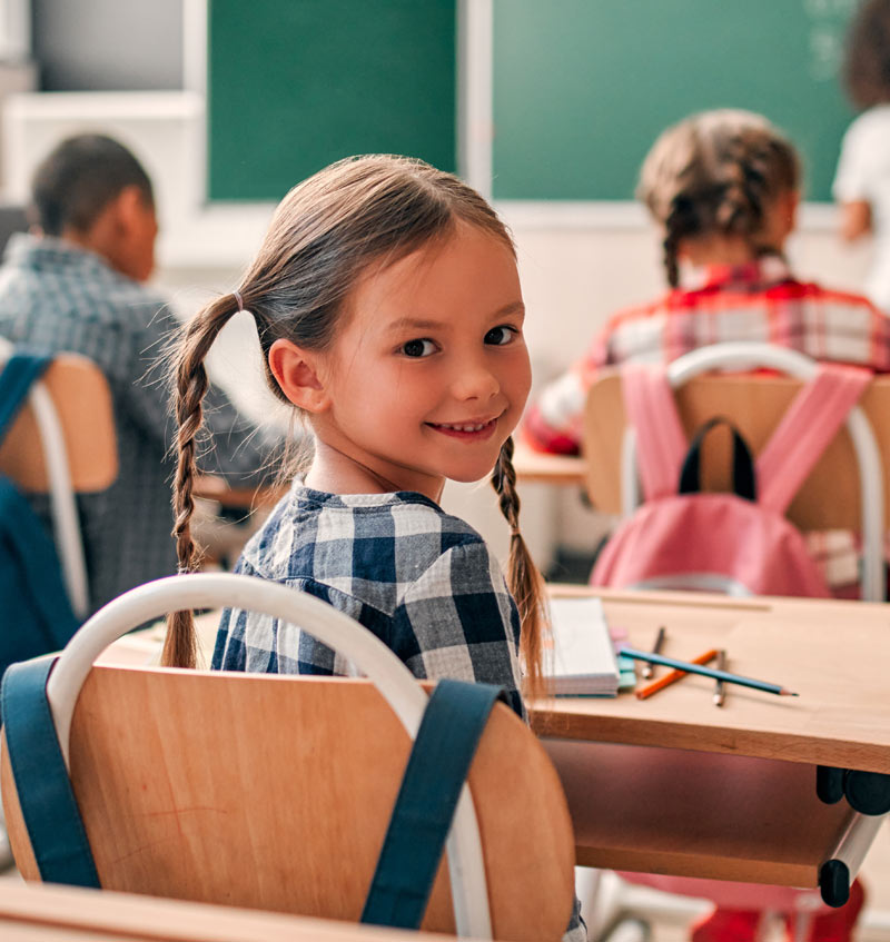 Young girl sitting at her desk in school